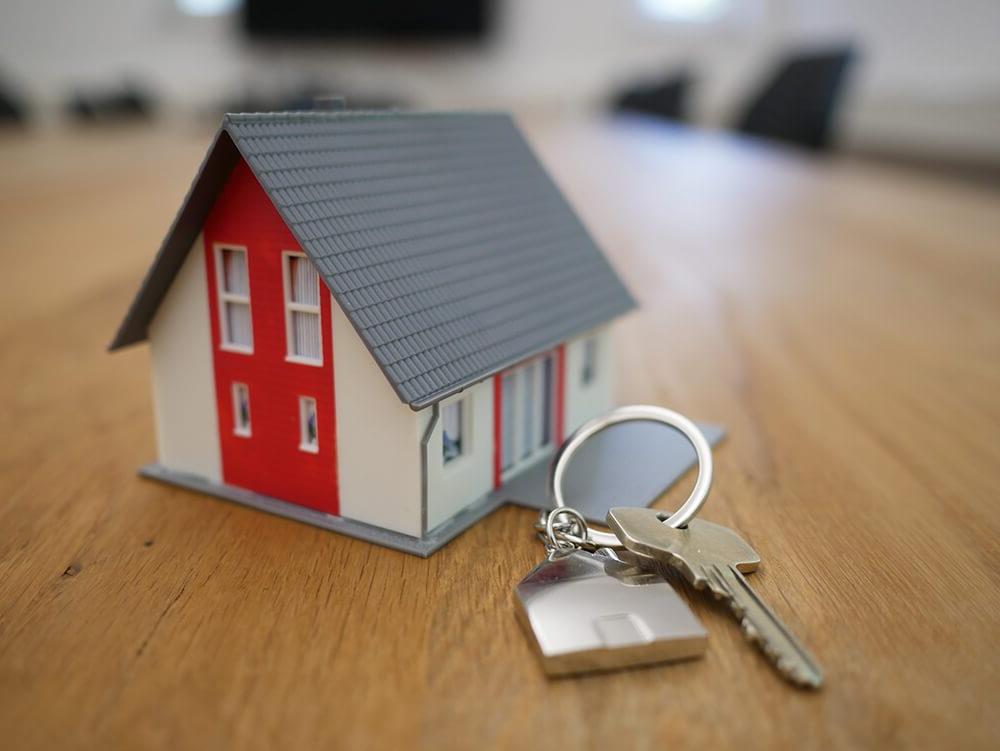 房子旁边的木桌上有一间带钥匙的小房子
